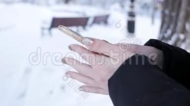一个女人手里拿着一个电话，想在寒冷的冬天打出租车